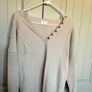 Women’s beige thermal top with decorative buttons.